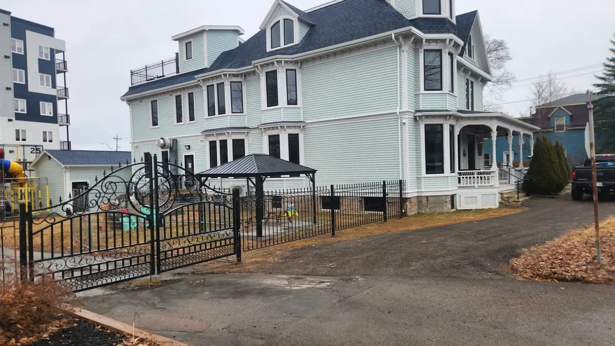Ornamental iron driveway gate and fence at heritage Victorian property with gazebo