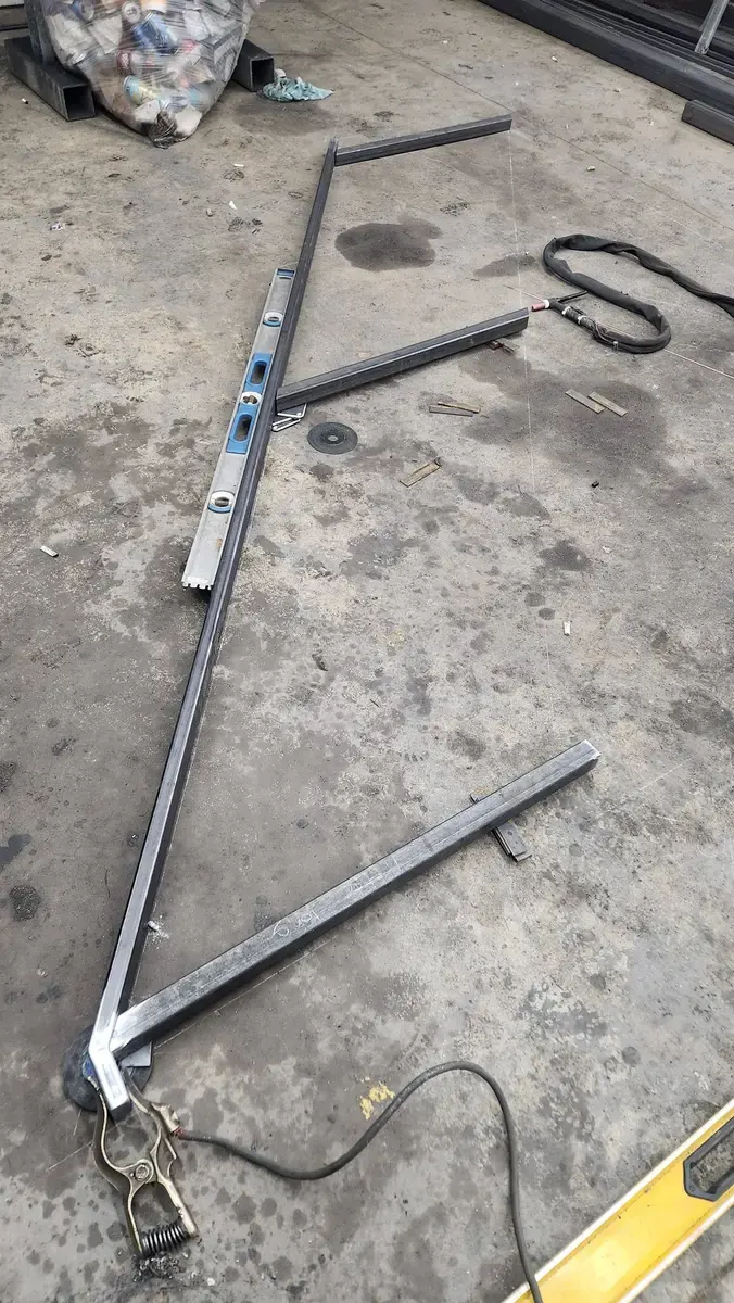Railing Z-frame laid out on shop floor with level for alignment check