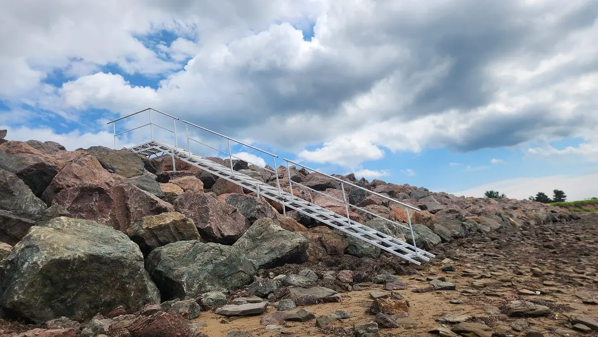 Aluminum beach access stairs installed on coastal rocks with ocean view, Shediac area