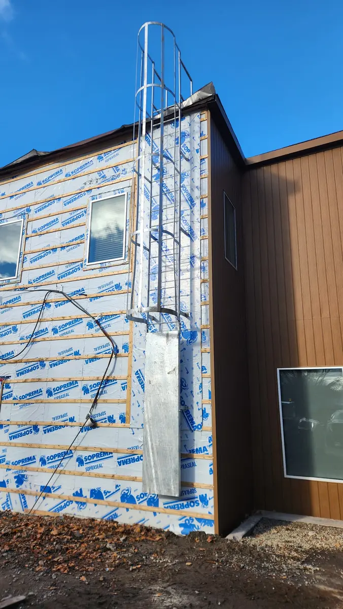 Aluminum roof access ladder with cage on new construction during envelope phase