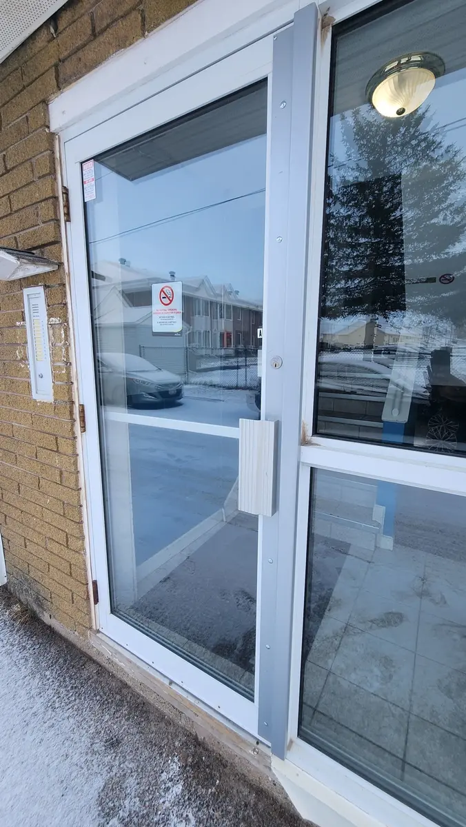 Commercial aluminum and glass entry door installation at apartment building