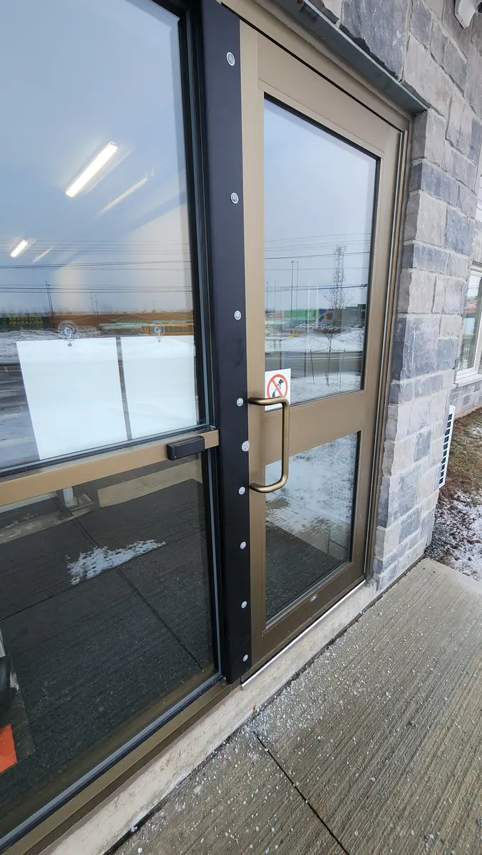Commercial storefront door with bronze finish and glass panels at retail location