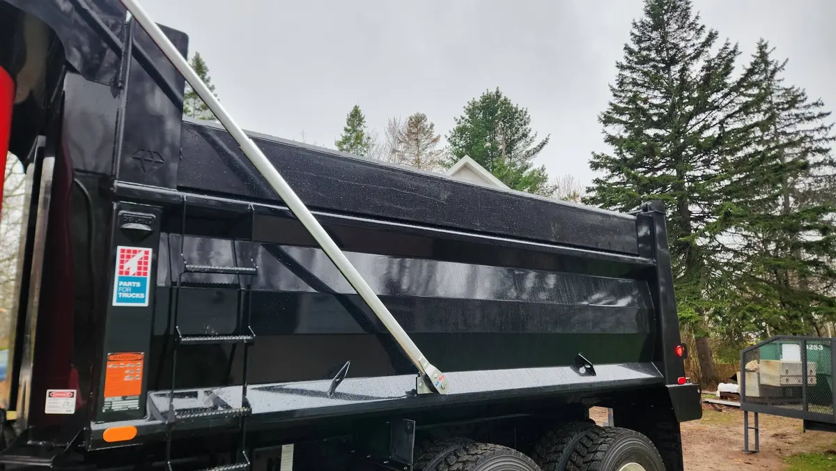 Custom fabricated heavy-duty dump truck box, side view showing reinforced steel panels