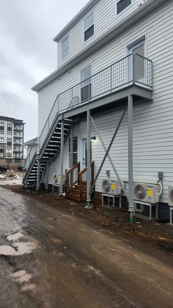 Exterior galvanized steel stairs and balcony railing on multi-unit apartment building