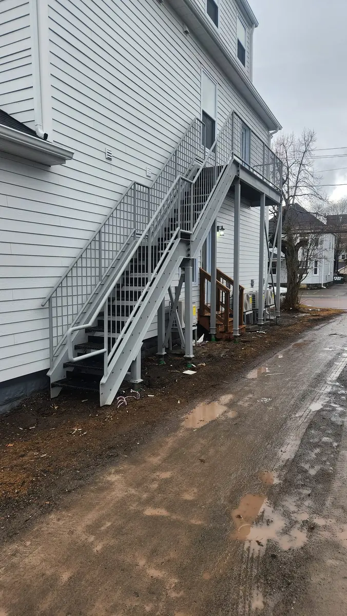 Alternate view of exterior apartment stairs showing full staircase and balcony structure