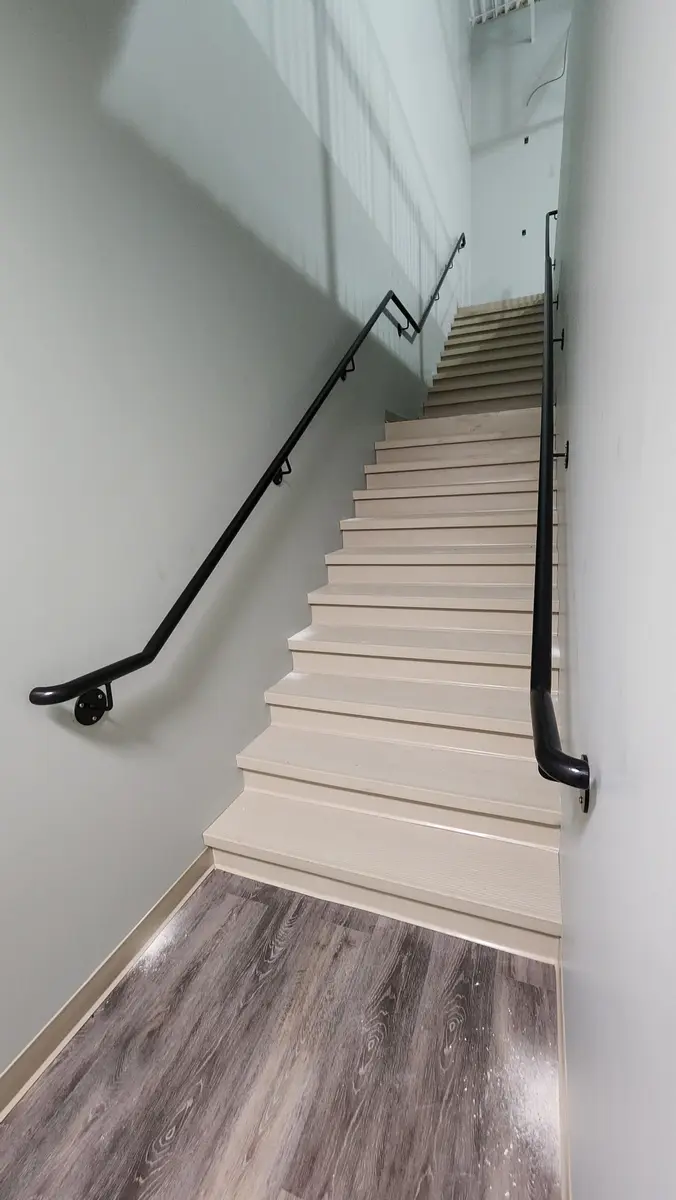 Galvanized steel beach access stairs on rocky hillside with ocean view