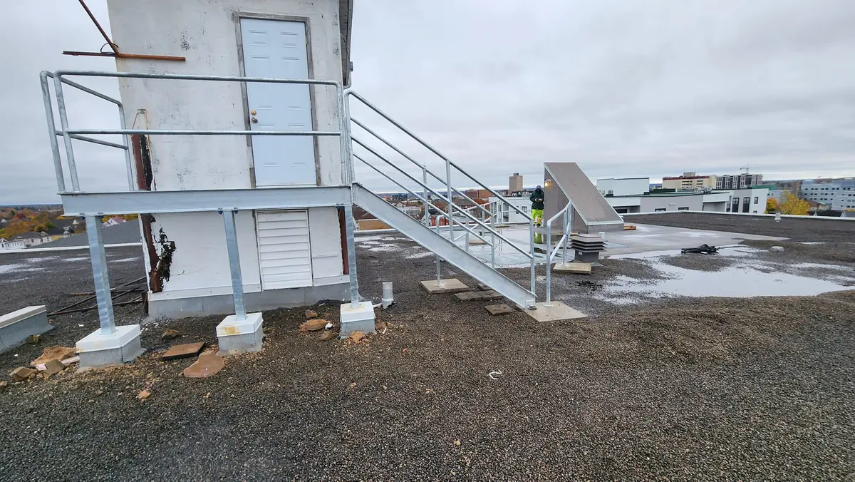 Galvanized rooftop access stairs and railings on commercial building roof