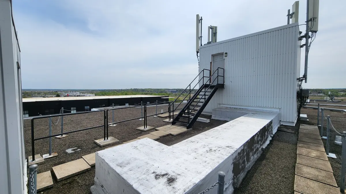 Rooftop stairs and safety railings at telecom tower site on commercial building