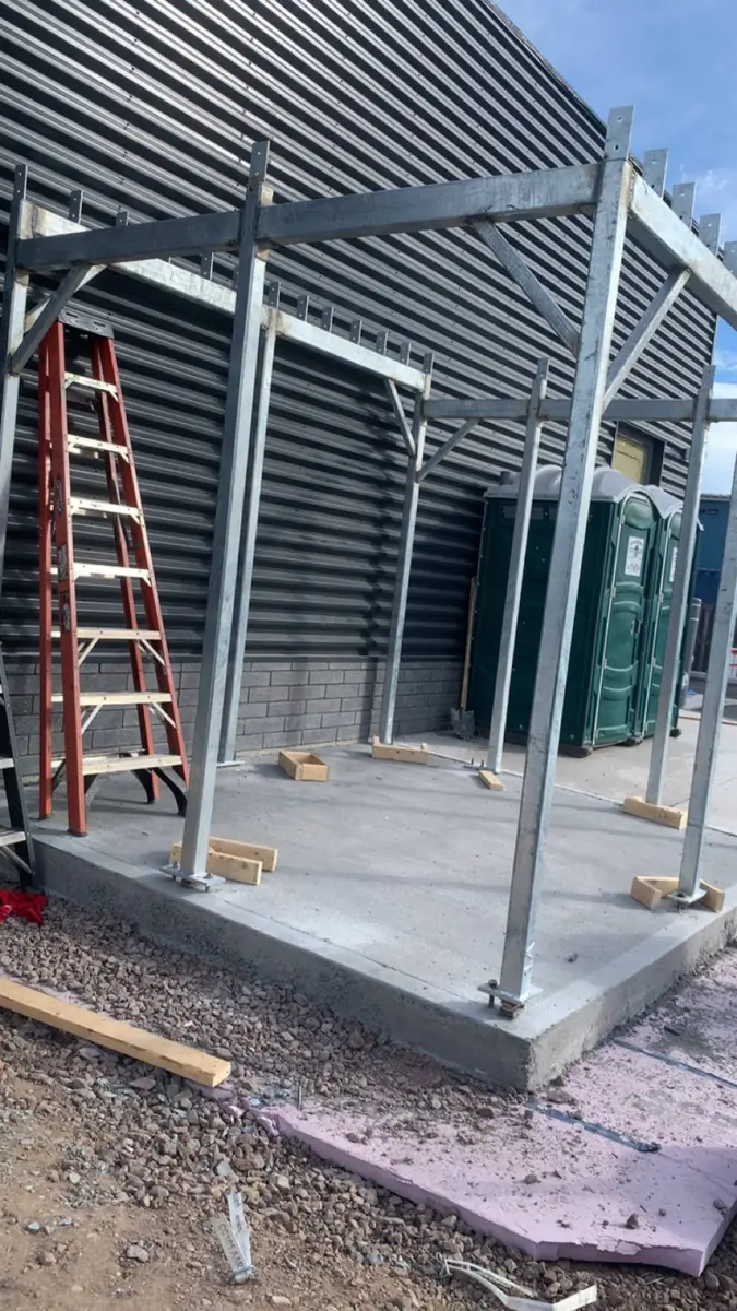 Structural steel enclosure frame under construction at commercial site